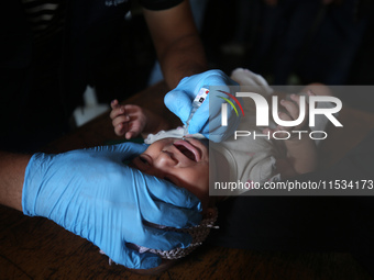 A Palestinian child receives a polio vaccination at a United Nations healthcare center in Deir Al-Balah in the central Gaza Strip, on Septem...