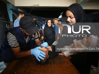 A Palestinian child receives a polio vaccination at a United Nations healthcare center in Deir Al-Balah in the central Gaza Strip, on Septem...