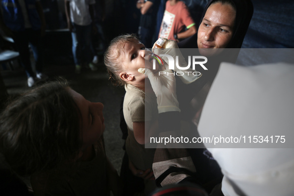 A Palestinian child receives a polio vaccination at a United Nations healthcare center in Deir Al-Balah in the central Gaza Strip, on Septem...