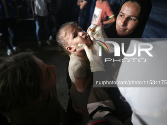 A Palestinian child receives a polio vaccination at a United Nations healthcare center in Deir Al-Balah in the central Gaza Strip, on Septem...