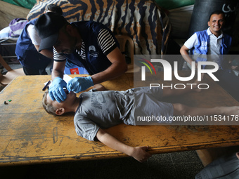 A Palestinian child receives a polio vaccination at a United Nations healthcare center in Deir Al-Balah in the central Gaza Strip, on Septem...