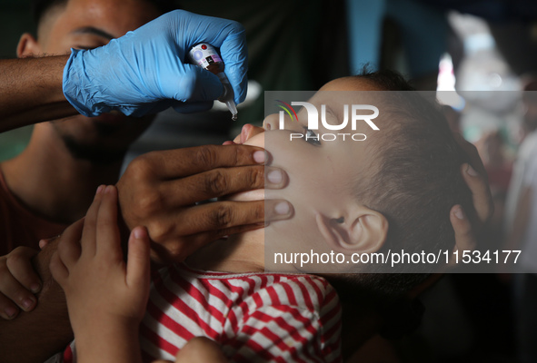 A Palestinian child receives a polio vaccination at a United Nations healthcare center in Deir Al-Balah in the central Gaza Strip, on Septem...