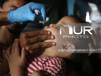 A Palestinian child receives a polio vaccination at a United Nations healthcare center in Deir Al-Balah in the central Gaza Strip, on Septem...