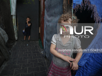 Displaced Palestinian children stand inside a United Nations school sheltering displaced people during a vaccination campaign in Deir Al-Bal...