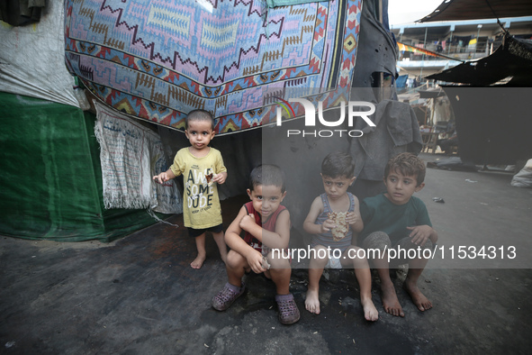 Displaced Palestinian children sit inside a United Nations school sheltering displaced people during a vaccination campaign in Deir Al-Balah...