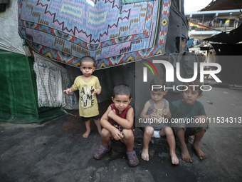 Displaced Palestinian children sit inside a United Nations school sheltering displaced people during a vaccination campaign in Deir Al-Balah...