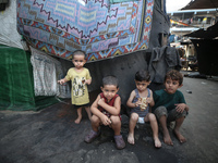 Displaced Palestinian children sit inside a United Nations school sheltering displaced people during a vaccination campaign in Deir Al-Balah...