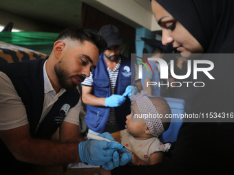 A health worker marks the finger of a Palestinian child vaccinated against polio in Deir Al-Balah in the central Gaza Strip, on September 1,...