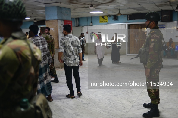 Bangladesh army personnel stand guard at Dhaka Medical College Hospital as medical services in the emergency department remain suspended in...