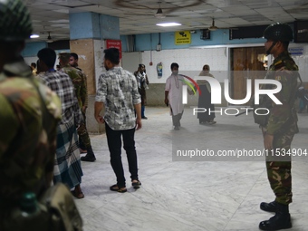 Bangladesh army personnel stand guard at Dhaka Medical College Hospital as medical services in the emergency department remain suspended in...