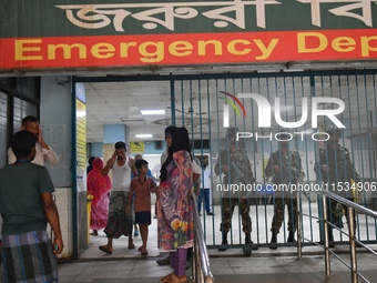 Bangladesh army personnel stand guard at Dhaka Medical College Hospital as medical services in the emergency department remain suspended in...