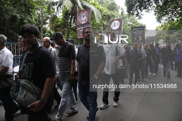 Ramakrishna Mission alumni and office staff take part in a protest march against a doctor's rape and murder in Kolkata, India, on September...