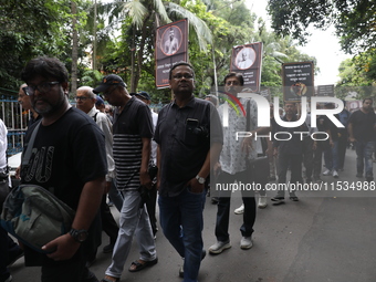 Ramakrishna Mission alumni and office staff take part in a protest march against a doctor's rape and murder in Kolkata, India, on September...