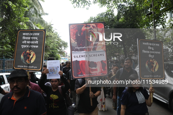 Ramakrishna Mission alumni and office staff take part in a protest march against a doctor's rape and murder in Kolkata, India, on September...