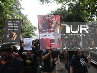 Ramakrishna Mission alumni and office staff take part in a protest march against a doctor's rape and murder in Kolkata, India, on September...