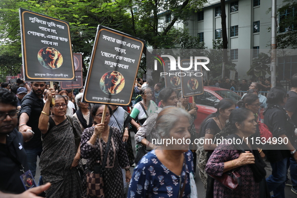 Ramakrishna Mission alumni and office staff take part in a protest march against a doctor's rape and murder in Kolkata, India, on September...