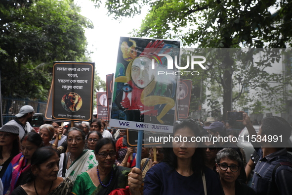 Ramakrishna Mission alumni and office staff take part in a protest march against a doctor's rape and murder in Kolkata, India, on September...