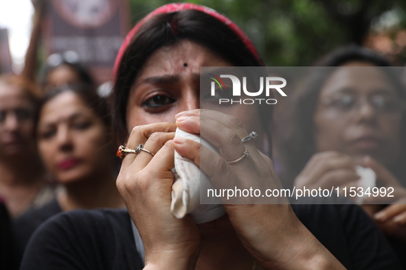 Ramakrishna Mission alumni and office staff take part in a protest march against a doctor's rape and murder in Kolkata, India, on September...