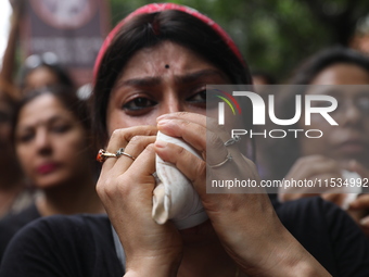 Ramakrishna Mission alumni and office staff take part in a protest march against a doctor's rape and murder in Kolkata, India, on September...