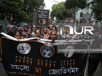 Ramakrishna Mission alumni and office staff take part in a protest march against a doctor's rape and murder in Kolkata, India, on September...