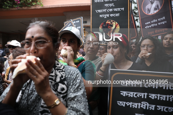 Ramakrishna Mission alumni and office staff take part in a protest march against a doctor's rape and murder in Kolkata, India, on September...