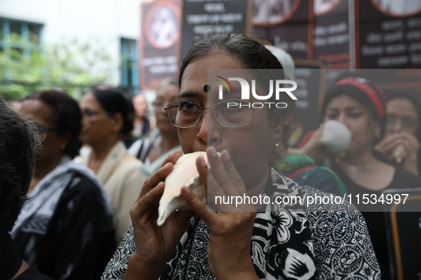 Ramakrishna Mission alumni and office staff take part in a protest march against a doctor's rape and murder in Kolkata, India, on September...