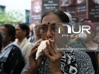 Ramakrishna Mission alumni and office staff take part in a protest march against a doctor's rape and murder in Kolkata, India, on September...