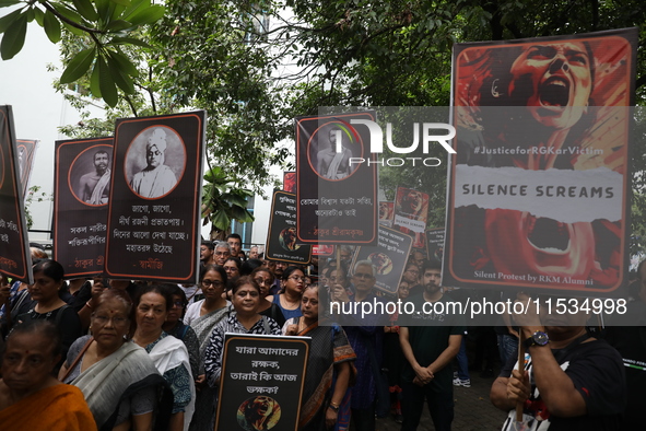 Ramakrishna Mission alumni and office staff take part in a protest march against a doctor's rape and murder in Kolkata, India, on September...