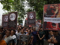 Ramakrishna Mission alumni and office staff take part in a protest march against a doctor's rape and murder in Kolkata, India, on September...