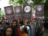 Ramakrishna Mission alumni and office staff take part in a protest march against a doctor's rape and murder in Kolkata, India, on September...