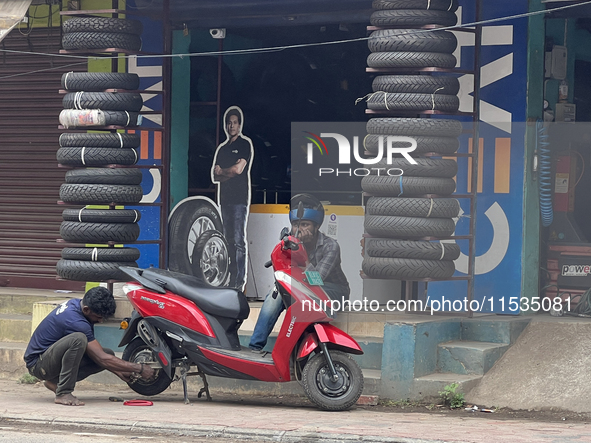 A man repairs the tire on a scooter in Thiruvananthapuram (Trivandrum), Kerala, India, on April 2, 2024. 