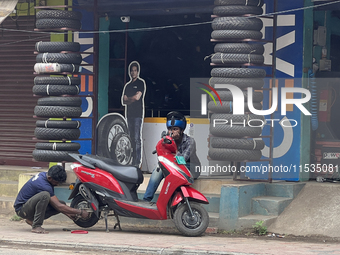 A man repairs the tire on a scooter in Thiruvananthapuram (Trivandrum), Kerala, India, on April 2, 2024. (