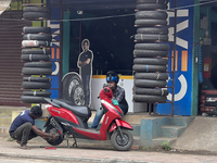 A man repairs the tire on a scooter in Thiruvananthapuram (Trivandrum), Kerala, India, on April 2, 2024. (