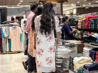 A woman shops for pants for a churidar at a textile shop in Thiruvananthapuram, Kerala, India, on April 10, 2024. (