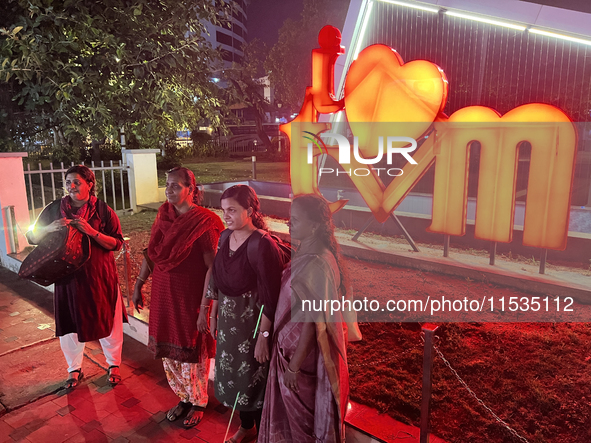 People pose by the 'I Love Trivandrum' sign in Thampanoor, Thiruvananthapuram (Trivandrum), Kerala, India, on April 1, 2024. 