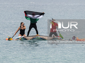 Dozens of activists participate in the international initiative ''Swim With Gaza'' on Nova Icaria beach, in Barcelona, Spain, on September 1...