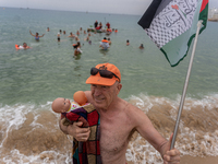 Dozens of activists participate in the international initiative ''Swim With Gaza'' on Nova Icaria beach, in Barcelona, Spain, on September 1...