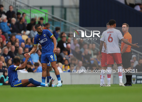 Omar Bugiel helps Alistair Smith up after a bad tackle during the Sky Bet League 2 match between AFC Wimbledon and Fleetwood Town at Plough...