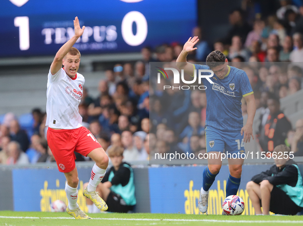 Rhys Bennett and Mat Stevens both claim the ball during the Sky Bet League 2 match between AFC Wimbledon and Fleetwood Town at Plough Lane i...