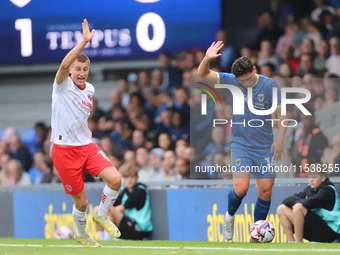 Rhys Bennett and Mat Stevens both claim the ball during the Sky Bet League 2 match between AFC Wimbledon and Fleetwood Town at Plough Lane i...