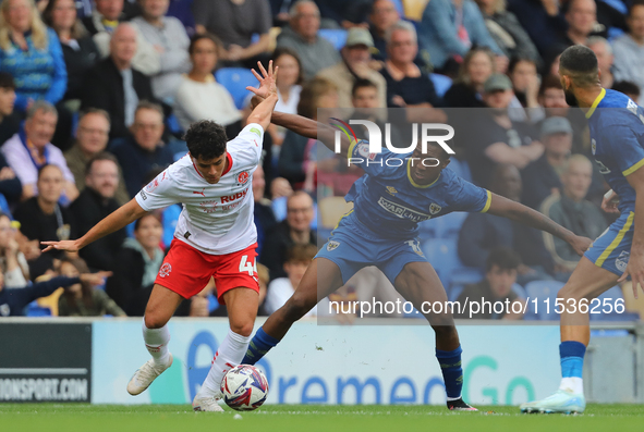 Phoenix Peterson of Fleetwood battles with Wimbledon's Josh Neufville during the Sky Bet League 2 match between AFC Wimbledon and Fleetwood...