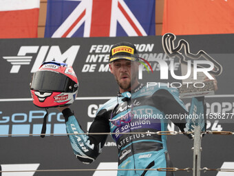 Jake Dixon stands on the winner's podium for the Moto2 category, representing the CFMOTO Inde Aspar Team on a KALEX bike, during the Moto Gr...