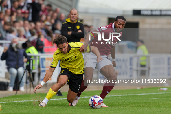 Burton Albion's Tomas Kalinauskas is challenged by Northampton Town's Ali Koiki during the first half of the Sky Bet League 1 match between...