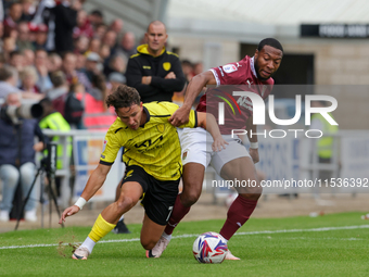 Burton Albion's Tomas Kalinauskas is challenged by Northampton Town's Ali Koiki during the first half of the Sky Bet League 1 match between...