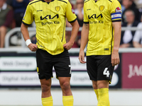 Burton Albion's Tomas Kalinauskas and Burton Albion's captain Elliot Watt stand over the ball during the first half of the Sky Bet League 1...