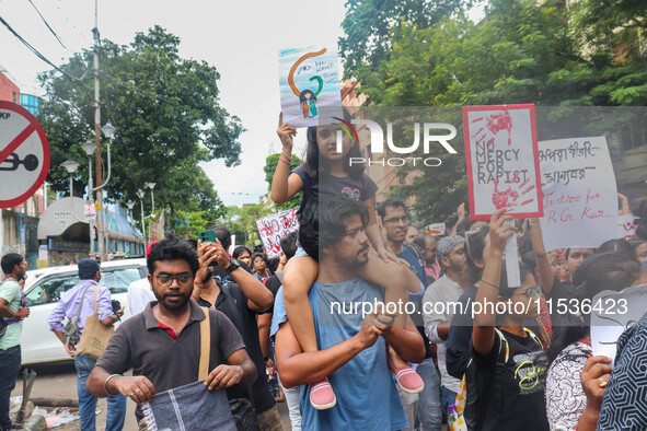 Students and citizens hold various posters during a rally in Kolkata, India, on September 1, 2024, demanding punishment for the accused invo...