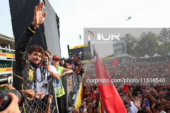 Charles Leclerc of Ferrari celebrates with fans after the Formula 1 Italian Grand Prix at Autodromo Nazionale di Monza in Monza, Italy on Se...