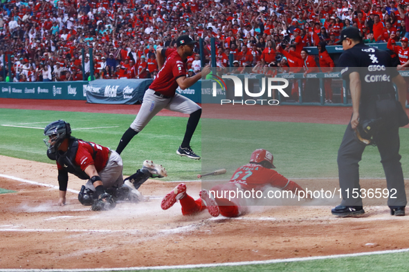 Jose Pirela #67 of Diablos Rojos slides to home plate to avoid Ricardo Valenzuela #28 of Guerreros de Oaxaca's tag during match 6 of the Mex...