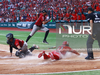 Jose Pirela #67 of Diablos Rojos slides to home plate to avoid Ricardo Valenzuela #28 of Guerreros de Oaxaca's tag during match 6 of the Mex...