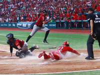 Jose Pirela #67 of Diablos Rojos slides to home plate to avoid Ricardo Valenzuela #28 of Guerreros de Oaxaca's tag during match 6 of the Mex...